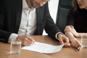 Hombre firmando los papeles de divorcio, en el despacho de un notario.