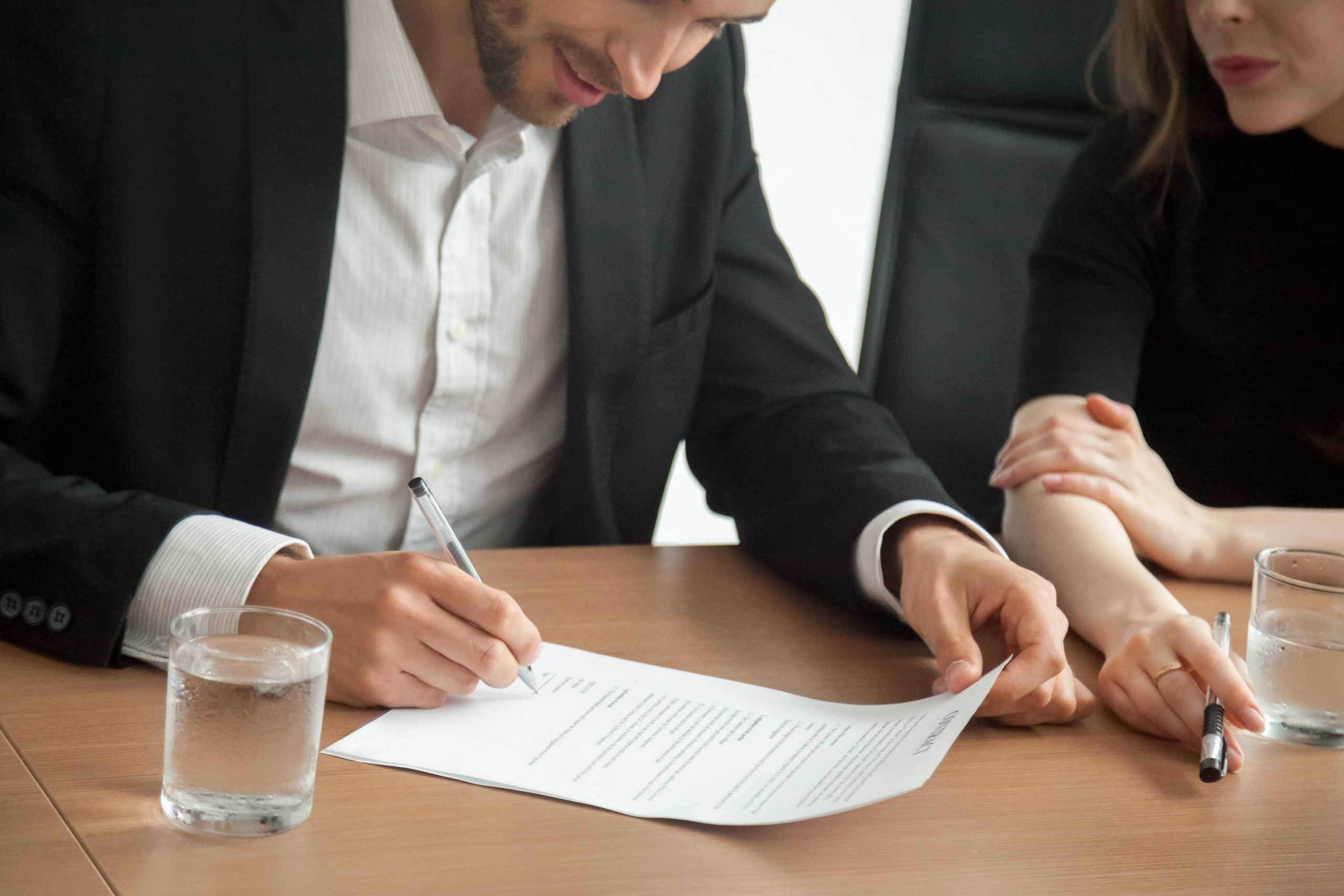 Hombre firmando los papeles de divorcio, en el despacho de un notario.